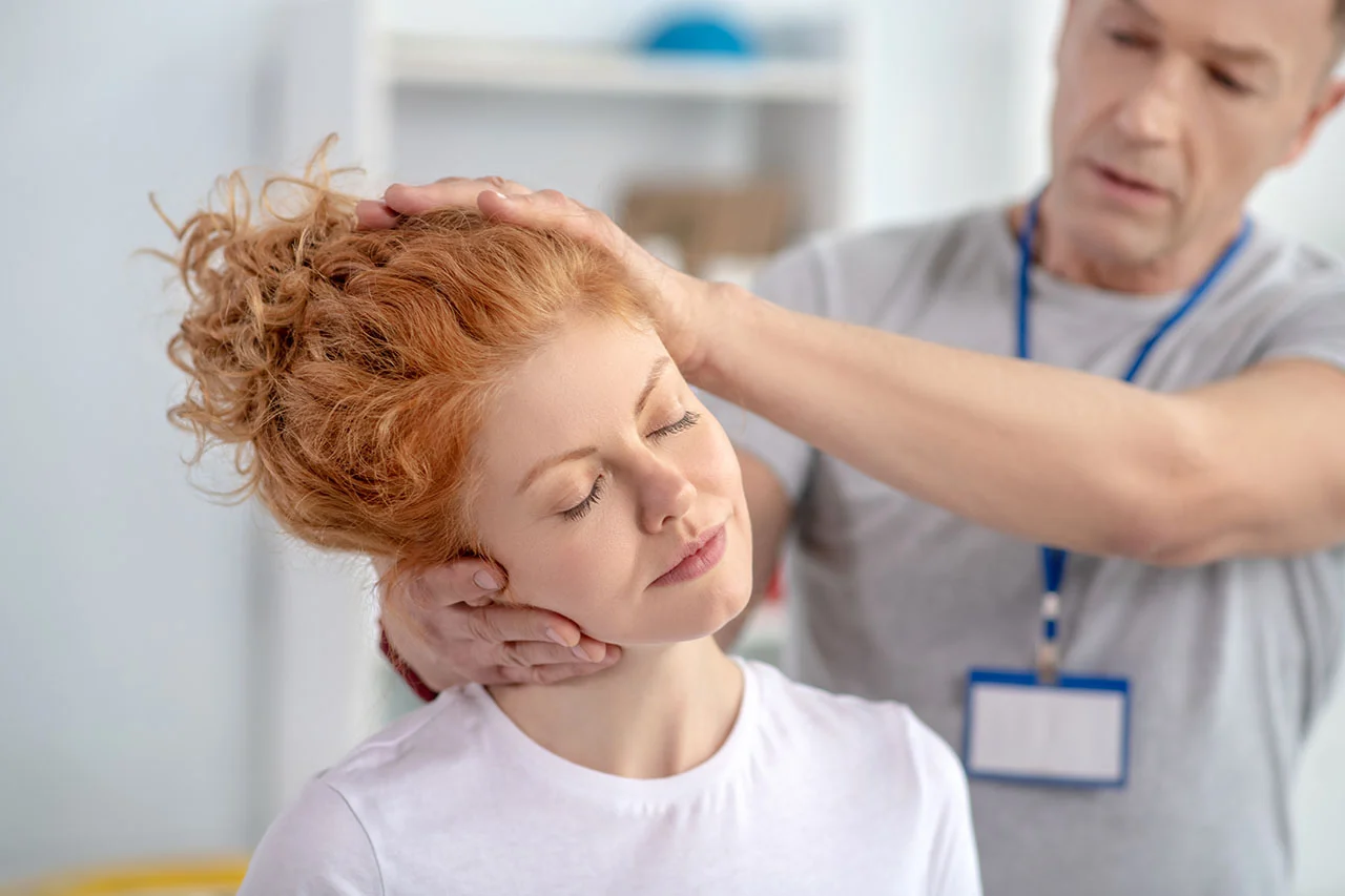 Chiropractor performing a cervical spinal adjustment for neck pain treatment at Rally Point Health and Rehab in Markham ON